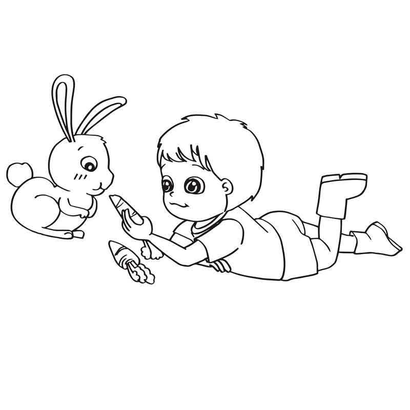Мальчик кормит кролика